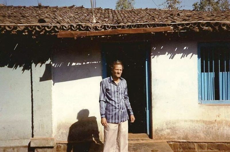 Shri's father standing infront of his mud house in Belagavi
