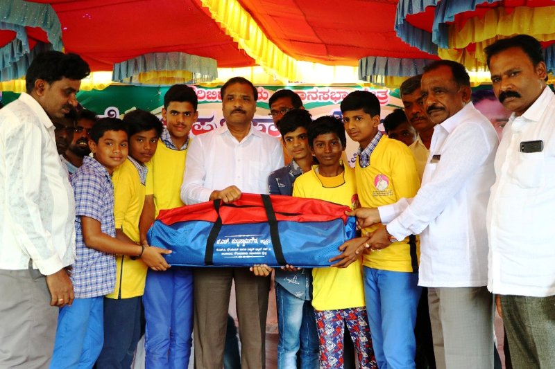 A photo of K. H. Puttaswamy Gowda taken while he was distributing cricket kit to the kids in Karnataka