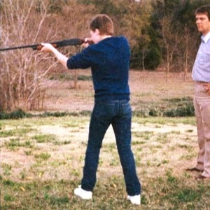 Chris with his father firing a double-barrel shotgun