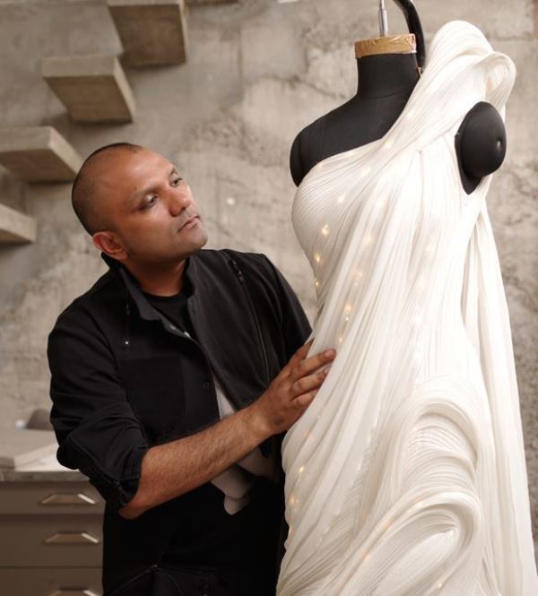 Gaurav Gupta posing with the artificial intelligence-inspired sari-gown designed in collaboration with Vogue and IBM in 2017