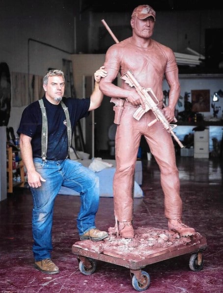 Greg Marra posing for a photo with Chris Kyle's statue