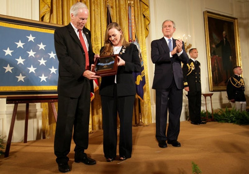 Michael's parents holding the Medal of Honor with President Bush standing next to them