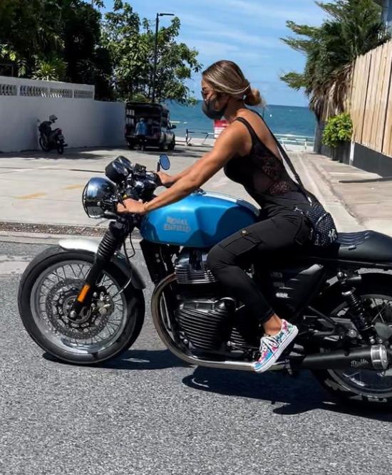 Nicha riding her custom Royal Enfield motorcycle