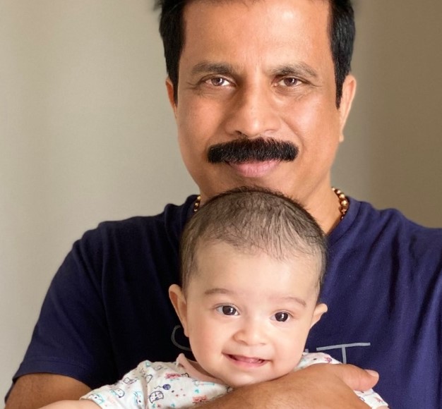Porinju Veliyath posing with his grandchild