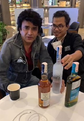 Raja Chaudhary with bottles of alcohol