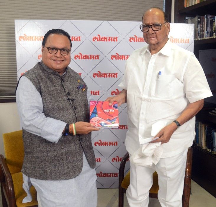 Vijay Darda presenting his book to Sharad Pawar (right)