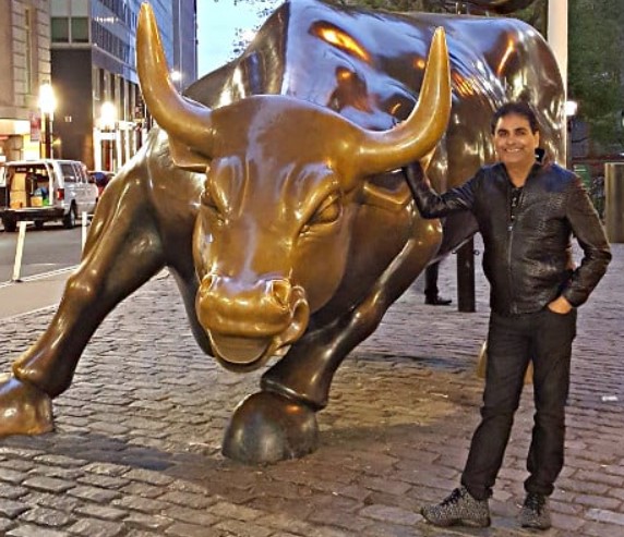 Vijay Kedia posing with a stock market bull statue