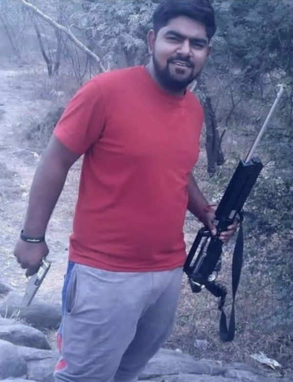 Monu Manesar holding his pistol and rifle