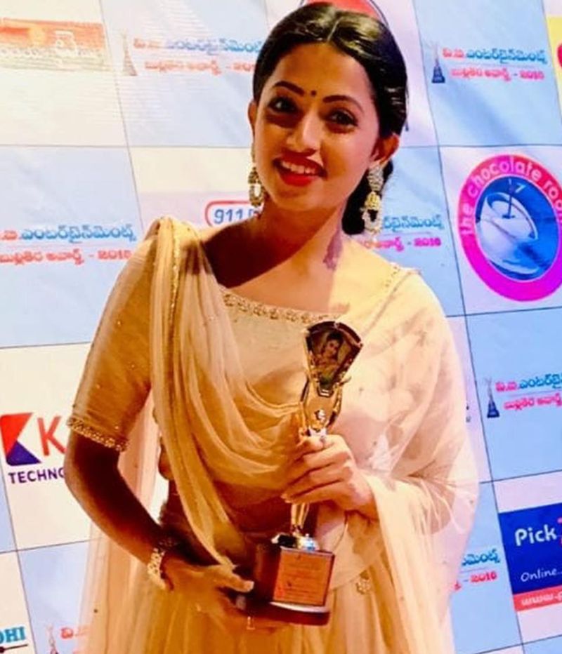 Navya holding the Best Actress Award