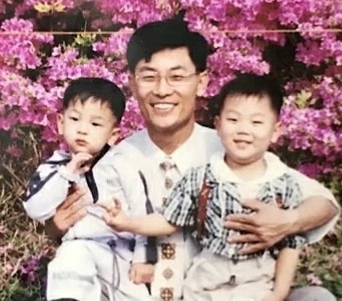 A childhood image of Kim Woo-jin with his father and brother