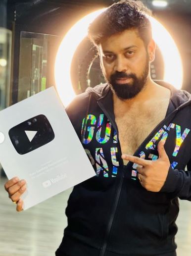 Aata Sandeep posing with his Silver YouTube Play Button