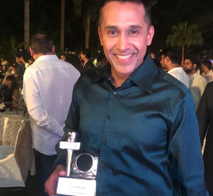 Anand Narasimhan posing with his ENBA Award for Best Anchor in English, 2021