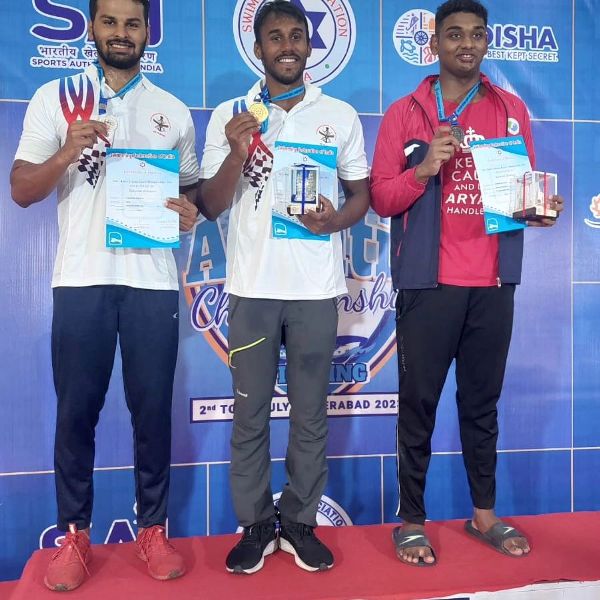 Likith Selvaraj (centre) after winning gold medal in the 72nd Senior National Aquatic Championship in 2018