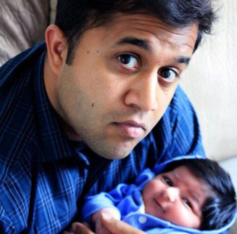 Omi Vaidya holding his son