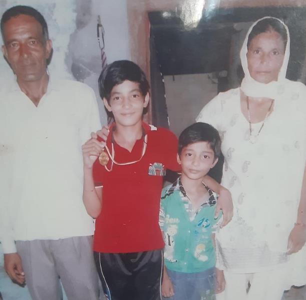 A childhood image of Parveen Hooda with her parents and younger brother