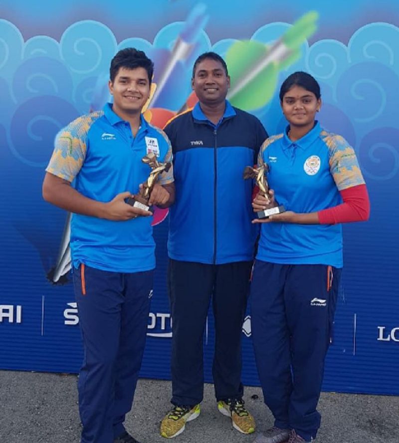 Abhishek Verma posing with teammate after winning silver in compound mixed team event