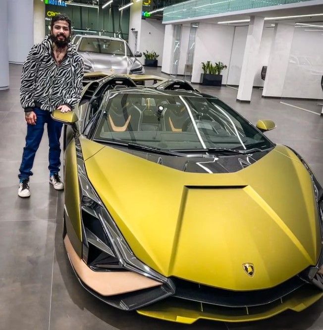 Anurag Dobhal posing with his Lamborghini car