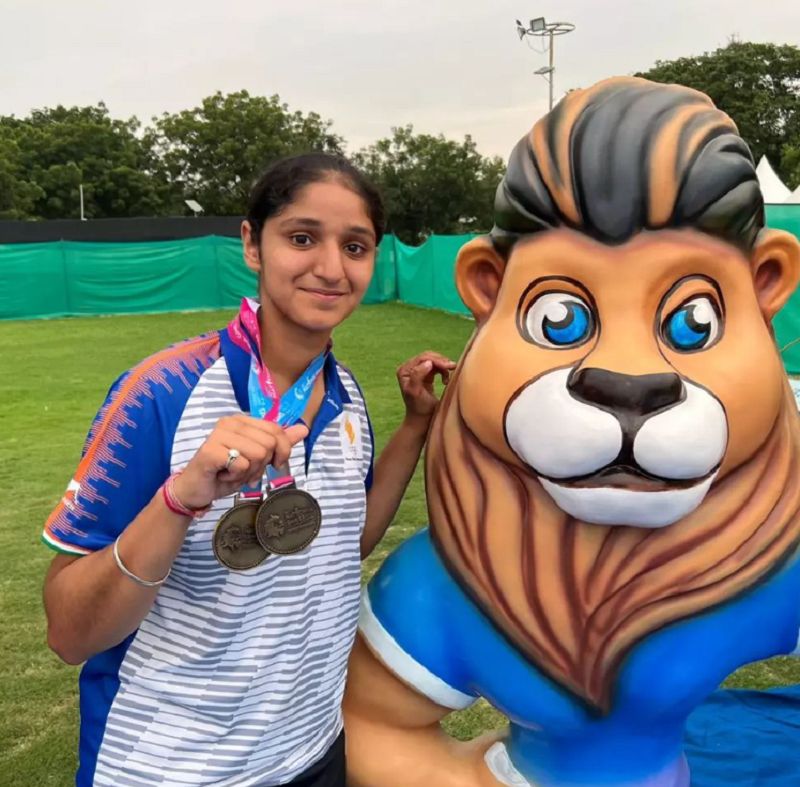 Bhajan Kaur posing with two bronze medals in the National Games