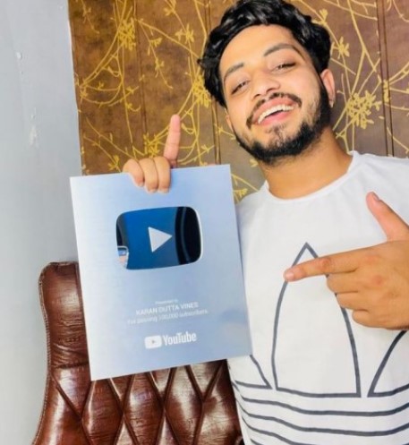 Karan Dutta posing with a silver YouTube button