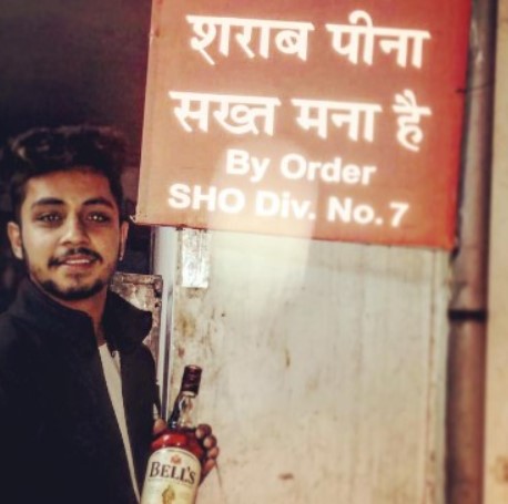  Karan Dutta holding a bottle of alcohol