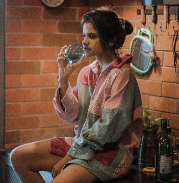 Maya S. Krishnan posing with the bottle of alcohol
