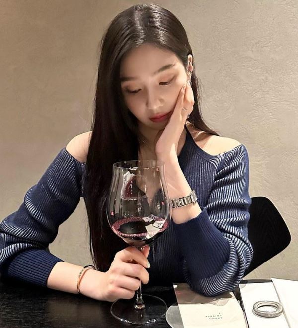 Joy holding a glass of red wine