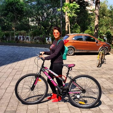 Karuna Pandey while posing with a cycle