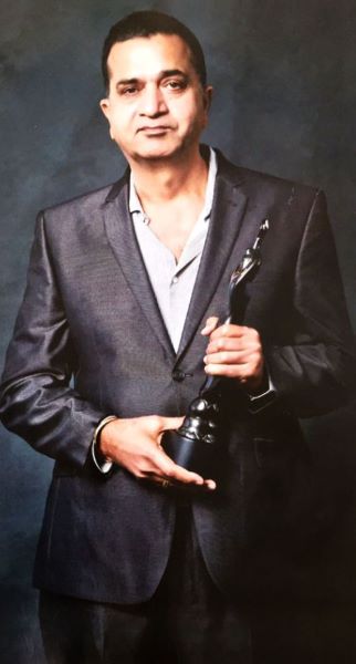 Sham Kaushal posing with the Best Action award that he received at the International Indian Film Academy Awards