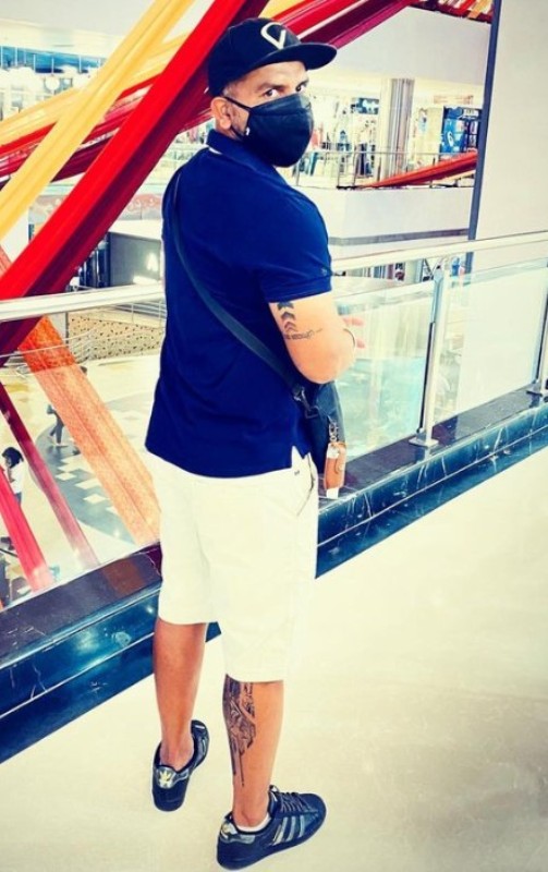 Tattoos of T Dilip on his arm and leg