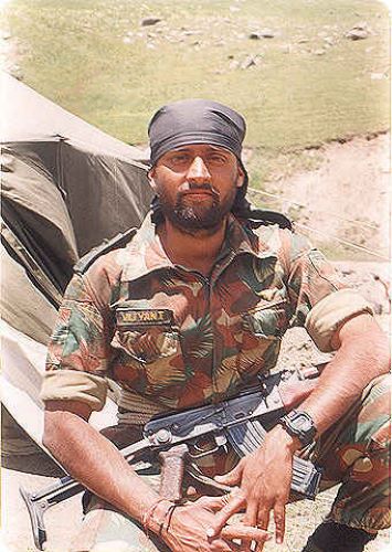 Thapar posing for a photo with an AK-47 on his lap