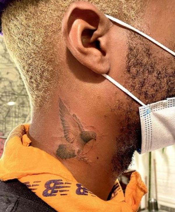 A pigeon tattoo on the right side of Salehe Bembury's neck