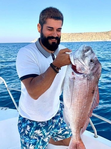Burak Özçivit holding a fish