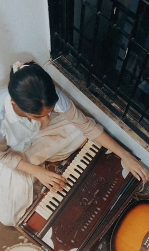 Daisy Khatri playing a harmonium
