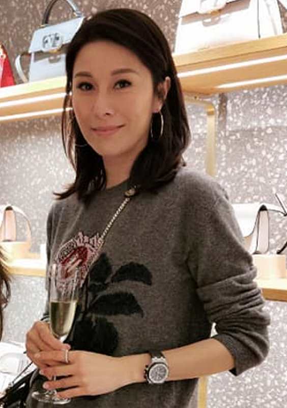 Lai Suk-yin holding a glass of alcohol