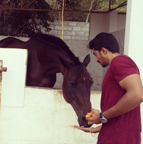 Maganti Srinath feeding a horse