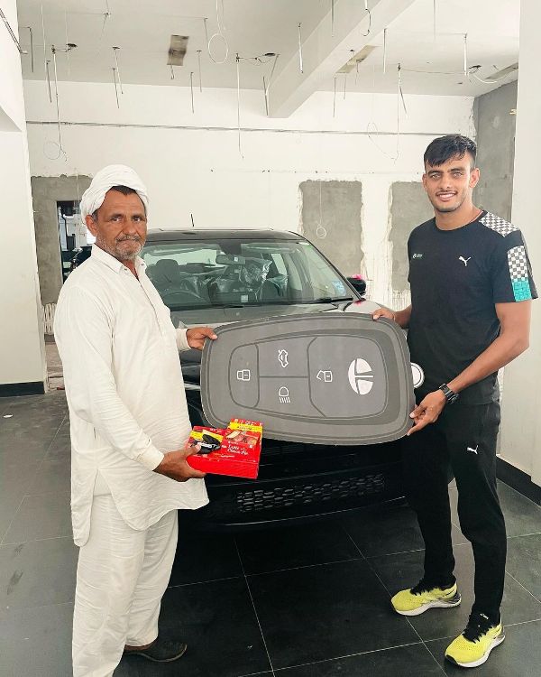 Manjeet Dahiya, along with his father, after buying Tata Harrier