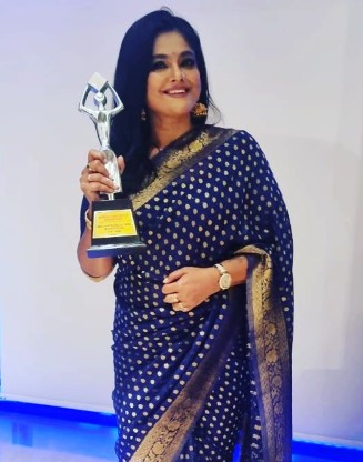 Manju Pillai posing with her award
