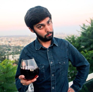 Neel Nanda posing with a glass of wine