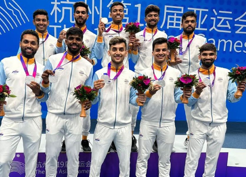 Rohan Kapoor (bottom row, second from left) with the Indian men's team posing with the silver medal that they won at the 19th Asian Games
