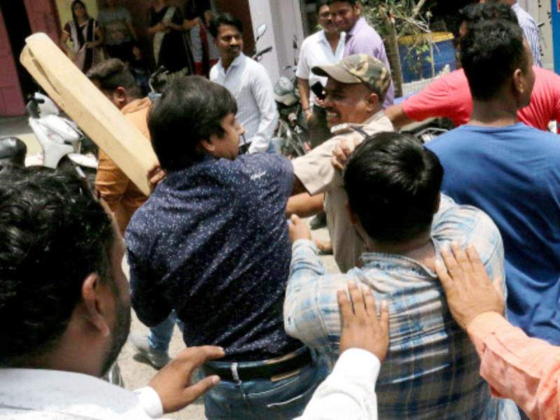 A cop trying to restrain Akash while he was hitting a civic official with a bat