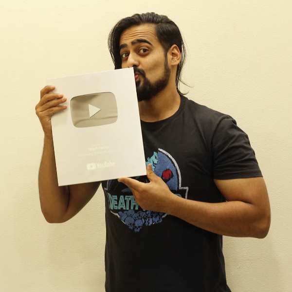 Akash Dodeja posing with his YouTube Silver Play Button