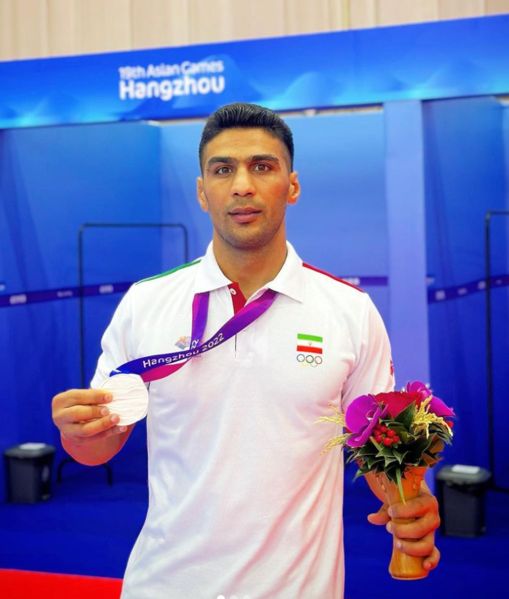 Amirhossein Bastami posing with his silver medal at the 2022 Asian Games