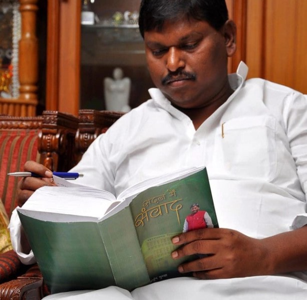 Arjun Munda sitting with his book Sadan Mein Samvaad