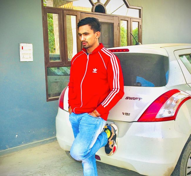 Ashu Singh posing with his car