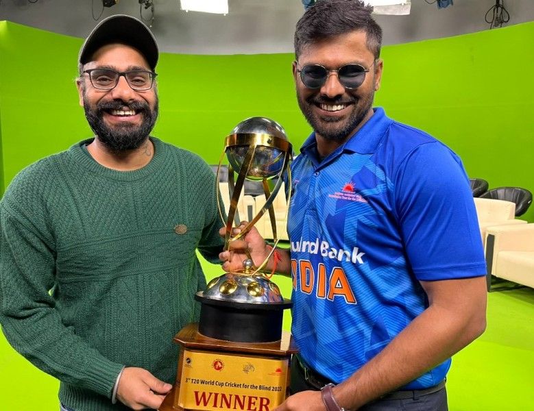 Illuri Ajay Kumar Reddy (right) posing with a trophy during a photoshoot