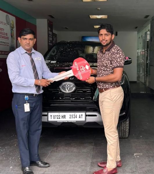 Nitesh Kumar (right) after purchasing his new car Toyota Fortuner