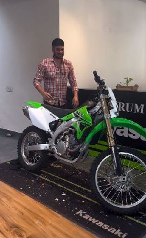 Rohit Kumar standing with his Kawasaki bike