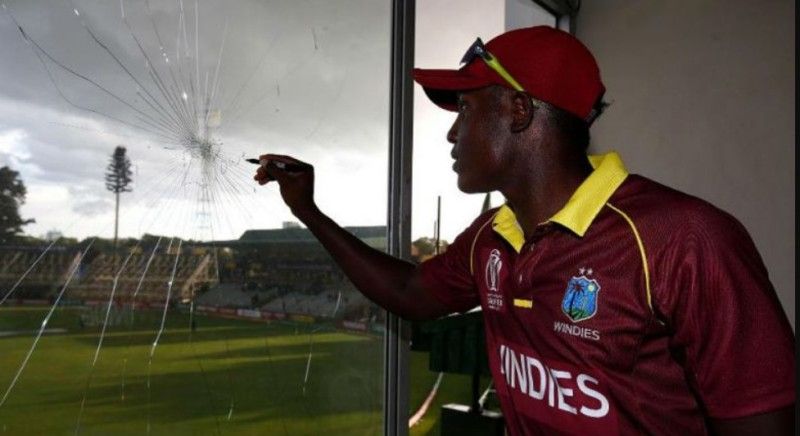 Rovman Powell signing on the glass window which he broke while hitting a six