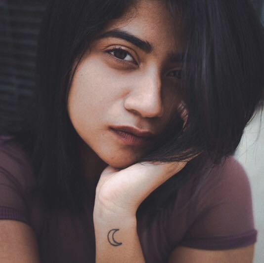 A moon phase tattoo on left hand of Abhignya Vuthaluru