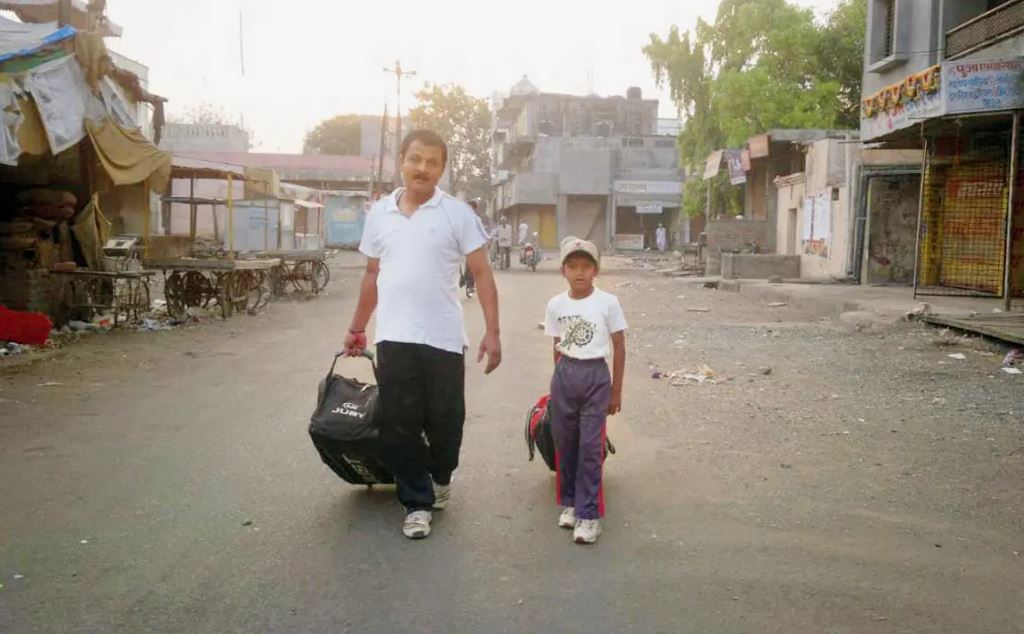 Sachin Dhas (right), at the age of six, heading to practice with father, Sanjay Dhas, in Beed